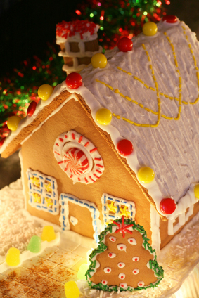 festively lit homemade gingerbread house with christmas tree and decorations