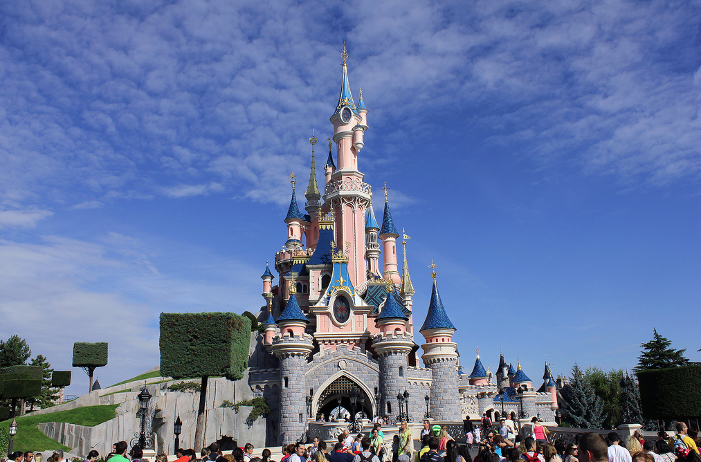 disneyland paris pink castle with crowds of people 