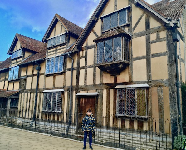 child boy posing in front of william shakespeare birthplace at stratford upon avon