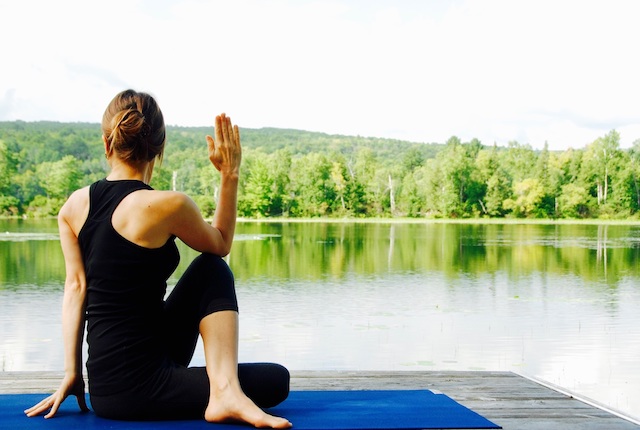 woman doing yoga by the lake 