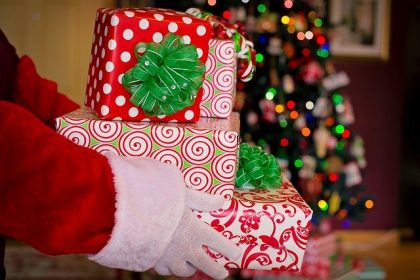 Santa Claus puts presents under the Christmas tree