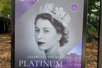 Poster showing Queen Elizabeth wearing crown and pearl necklace in black and white vintage image for a special display at Buckingham palace for Platinum Jubilee