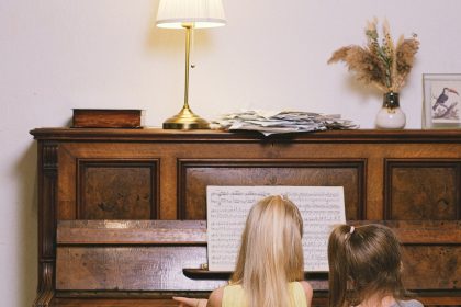 two young girls sitting at a piano