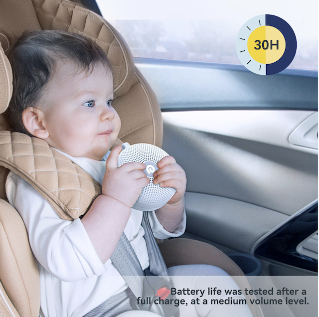 baby holds Sleep Machine in the car