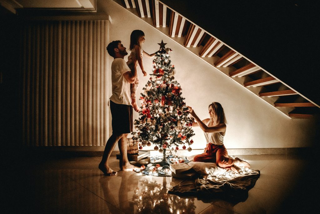 Mum dad and daughter preparing the Christmas tree