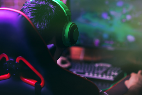 child playing video games in front of a computer 