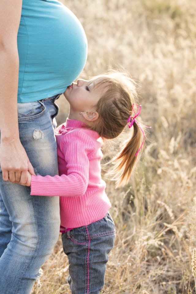 pregnancy girl kissing mum's tummy pexels-pixabay